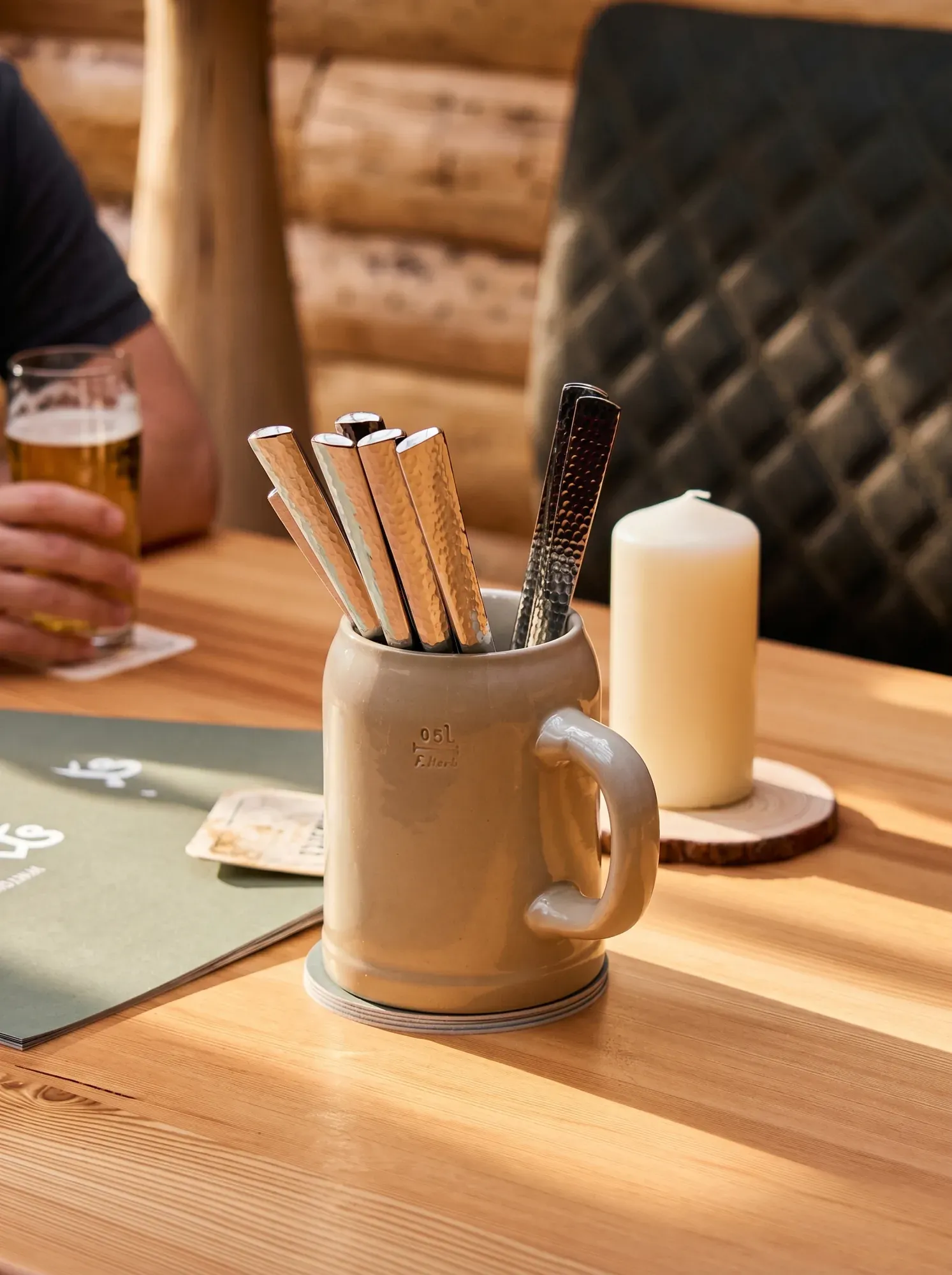 Besteck im Bierkrug und Kerze auf dem Tisch im Wirtshaus Paula